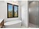 Luxurious bathroom featuring a freestanding tub, walk-in shower and a modern chandelier at 8245 E Via Del Sol Dr, Scottsdale, AZ 85255