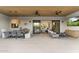 Spacious covered patio featuring a dining area, lounging area, and seamless indoor-outdoor living with sliding glass doors at 8245 E Via Del Sol Dr, Scottsdale, AZ 85255