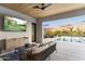 Stylish covered patio with a ceiling fan, a comfortable couch, and a view of the pool and yard at 8245 E Via Del Sol Dr, Scottsdale, AZ 85255