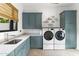 Well-equipped laundry room with blue cabinets, sink, counter space and modern machines at 8245 E Via Del Sol Dr, Scottsdale, AZ 85255