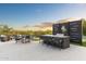 Outdoor kitchen with a built-in grill, bar seating, and an adjacent comfortable lounging area at 8245 E Via Del Sol Dr, Scottsdale, AZ 85255