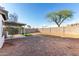 Backyard with gravel, some turf, covered patio, and a block fence with mature trees at 8576 E Jasper St, Gold Canyon, AZ 85118