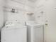 Bright laundry room featuring a white washer, dryer, and overhead wire shelving at 8576 E Jasper St, Gold Canyon, AZ 85118