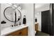 Stylish bathroom with wooden cabinets, quartz countertops, an oval mirror, and dark hardware at 8631 E Jackrabbit Rd, Scottsdale, AZ 85250