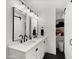 Bathroom featuring double sinks, black hardware, and closet space at 8631 E Jackrabbit Rd, Scottsdale, AZ 85250