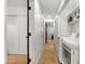 Bright hallway with wooden floors, white walls, laundry area and dark-trimmed door frames at 8631 E Jackrabbit Rd, Scottsdale, AZ 85250