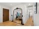 Bright hallway with wood floors and a large decorative mirror reflecting the open living space at 8631 E Jackrabbit Rd, Scottsdale, AZ 85250