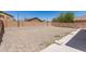 Backyard featuring a gravel landscape, concrete patio, and block fence at 906 S 242Nd Dr, Buckeye, AZ 85326