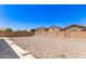Backyard featuring a gravel landscape, concrete patio, and block fence at 906 S 242Nd Dr, Buckeye, AZ 85326