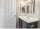 Bathroom featuring a vanity with sink, gray cabinets, a framed mirror, and white door at 906 S 242Nd Dr, Buckeye, AZ 85326