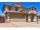 Two-story home featuring a neutral stucco facade, attached two-car garage, and well-maintained landscaping under a clear blue sky at 906 S 242Nd Dr, Buckeye, AZ 85326