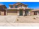Charming two-story home with a two car garage, desert landscaping, and a green front door at 906 S 242Nd Dr, Buckeye, AZ 85326
