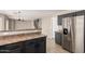 Modern kitchen features a stainless steel refrigerator, dark cabinets, and a tile floor at 906 S 242Nd Dr, Buckeye, AZ 85326