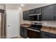 This kitchen features stainless steel appliances, dark cabinets and neutral countertops at 906 S 242Nd Dr, Buckeye, AZ 85326
