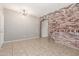 Charming living room with an exposed brick wall, stylish lighting, and tile flooring at 906 S 242Nd Dr, Buckeye, AZ 85326
