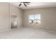 Bright main bedroom features a ceiling fan, carpet, and an ensuite bathroom with glass shower at 906 S 242Nd Dr, Buckeye, AZ 85326