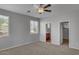Spacious bedroom with a ceiling fan, two windows, and an adjoining bathroom at 935 E Redondo Dr, Gilbert, AZ 85296