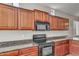 Kitchen showing cherry wood cabinets and stainless steel stove and microwave at 935 E Redondo Dr, Gilbert, AZ 85296