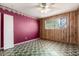 Unfurnished bedroom featuring red accent wall, wood paneling, and tiled floors at 1017 E Seldon Ln, Phoenix, AZ 85020