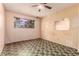 Simple bedroom with patterned wallpaper, linoleum floors, and a window overlooking foliage at 1017 E Seldon Ln, Phoenix, AZ 85020