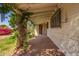 Covered patio with brick flooring provides a charming outdoor space framed by foliage at 1017 E Seldon Ln, Phoenix, AZ 85020
