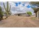 View of the backyard with a desert landscape and the exterior of the tan colored home at 10437 E Boulder Dr, Apache Junction, AZ 85120