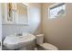 Bathroom with pedestal sink, toilet, mirror, and small window at 10437 E Boulder Dr, Apache Junction, AZ 85120
