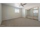 Comfortable bedroom featuring new carpet, ceiling fan, and a mirrored closet at 10437 E Boulder Dr, Apache Junction, AZ 85120
