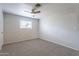 A neutral bedroom is equipped with a ceiling fan, carpet, and one window at 10437 E Boulder Dr, Apache Junction, AZ 85120