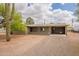 Exterior view of the home, featuring a covered carport, a well-kept lawn and desert landscaping at 10437 E Boulder Dr, Apache Junction, AZ 85120