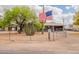 Home exterior featuring mature landscaping, a fence and a welcoming American flag at 10437 E Boulder Dr, Apache Junction, AZ 85120