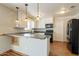 Bright kitchen featuring white cabinets, black appliances, and stylish pendant lighting at 10437 E Boulder Dr, Apache Junction, AZ 85120