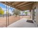 Covered patio overlooking a spacious backyard with mature trees and desert landscaping at 10437 E Boulder Dr, Apache Junction, AZ 85120