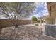 Spacious backyard with desert landscaping, mature tree, and a water fountain feature at 11003 E Kiva Ave, Mesa, AZ 85209