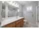 Bright bathroom with a wood vanity, large mirror, and a shower-tub combo at 11003 E Kiva Ave, Mesa, AZ 85209