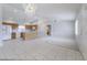 Open concept living space with kitchen, carpet, and tiled flooring leading to the front door at 11003 E Kiva Ave, Mesa, AZ 85209