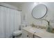 Cozy bathroom with round mirror, white vanity, and shower with curtain at 1247 W Boxelder Cir, Chandler, AZ 85224