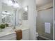 Neutral bathroom features a clear glass shower door, a white vanity and a large mirror at 1247 W Boxelder Cir, Chandler, AZ 85224