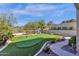 Backyard view of the putting green, desert landscaping, and clear blue sky at 13827 N Mesquite Ln, Fountain Hills, AZ 85268