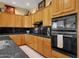 Well-appointed kitchen featuring black countertops, light wood cabinets, and stainless steel appliances at 13827 N Mesquite Ln, Fountain Hills, AZ 85268