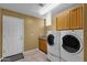 Well-equipped laundry room with washer, dryer, cabinets, sink, and access to the exterior at 13827 N Mesquite Ln, Fountain Hills, AZ 85268