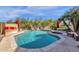 Inviting backyard oasis featuring a beautiful pool with a waterfall, lush landscaping, and comfortable seating areas at 13827 N Mesquite Ln, Fountain Hills, AZ 85268