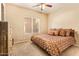Comfortable bedroom featuring carpet, neutral walls, bright window, and a queen size bed with decorative pillows at 1431 W Mountain Sky Ave, Phoenix, AZ 85045