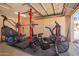 This garage has been turned into a gym with exercise equipment, weights, floor mats, and storage cabinets at 1431 W Mountain Sky Ave, Phoenix, AZ 85045