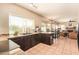 Open kitchen with dark cabinets, tile flooring, and view to the dining and living room at 1431 W Mountain Sky Ave, Phoenix, AZ 85045