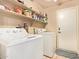 Functional laundry room equipped with a washer, dryer, shelving and a door to exterior, offering convenience at 1431 W Mountain Sky Ave, Phoenix, AZ 85045