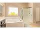 Bright bathroom with glass shower and separate soaking tub by the window at 1431 W Mountain Sky Ave, Phoenix, AZ 85045