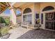 A tranquil shaded porch features seating and decor at the front of the home at 14334 W Shawnee Trl, Surprise, AZ 85374