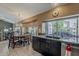 Bright kitchen and dining area featuring dark cabinets, granite counters, and a large view to the back yard at 14334 W Shawnee Trl, Surprise, AZ 85374