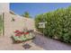 An enclosed area of the backyard features lovely desert landscaping, a bird feeder, and decorative flowers at 14334 W Shawnee Trl, Surprise, AZ 85374